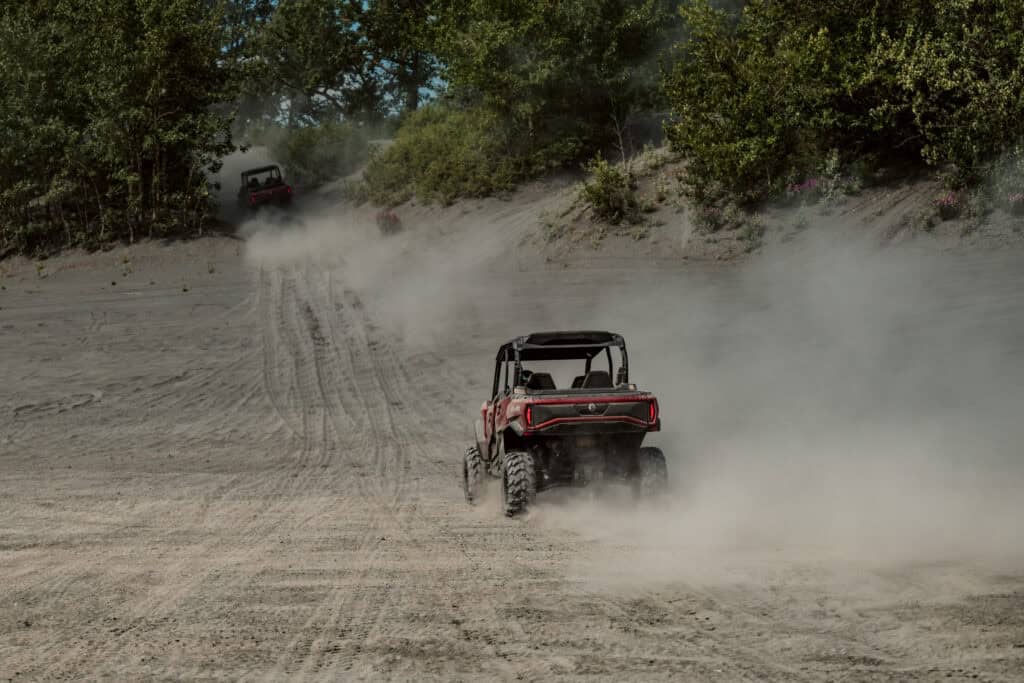 utv riding through the sand dunes on the trail