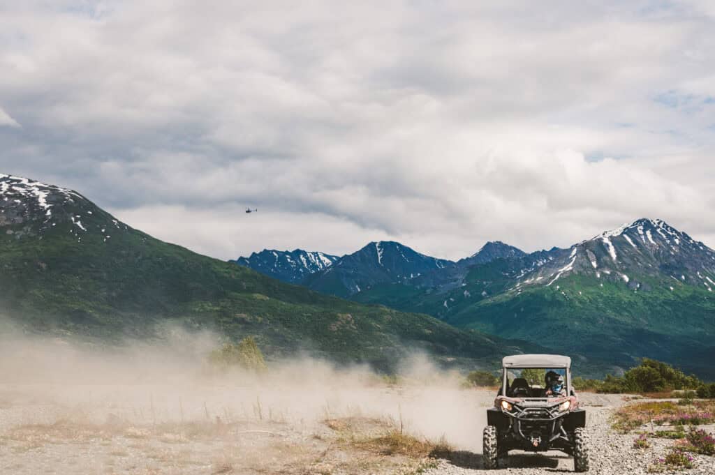 atv kicking up dust before the chugach mountains