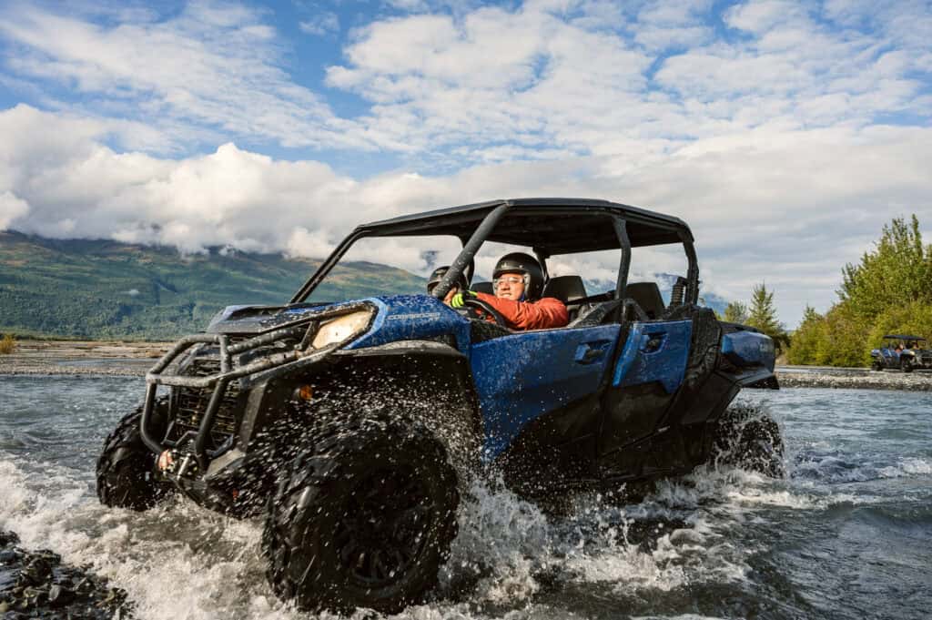 person crossing a creek in a utv in the knik river valley Alaska