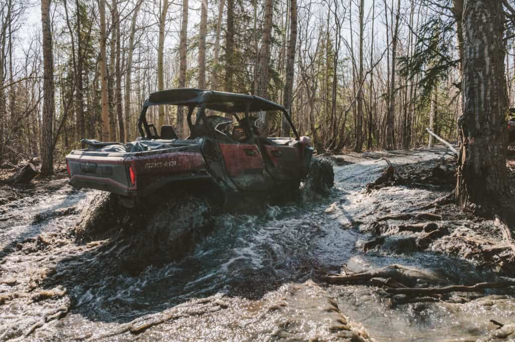 side by side splashing through a creek on the knik river trail