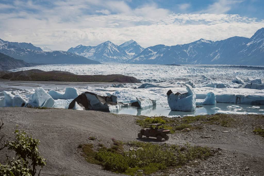 canam utv driving by the knik glacier lake with icebergs floating around on a sunny day in Alaska