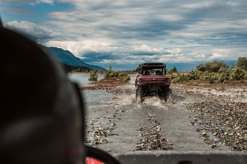 utvs riding down the trail to the knik glacier under cloudy skies in Alaska